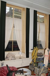 <p>Binnenzijde van de vensters op de begane grond. De indeling van de vouwblinden verwijst naar een oudere roedeverdeling van de ramen. </p>
